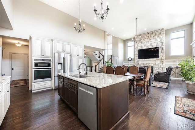 7032 Koufax Ct, Edwardsville, IL 62025 - kitchen featuring appliances with stainless steel finishes, a sink, healthy amount of natural light, dark wood-style flooring, and a towering ceiling