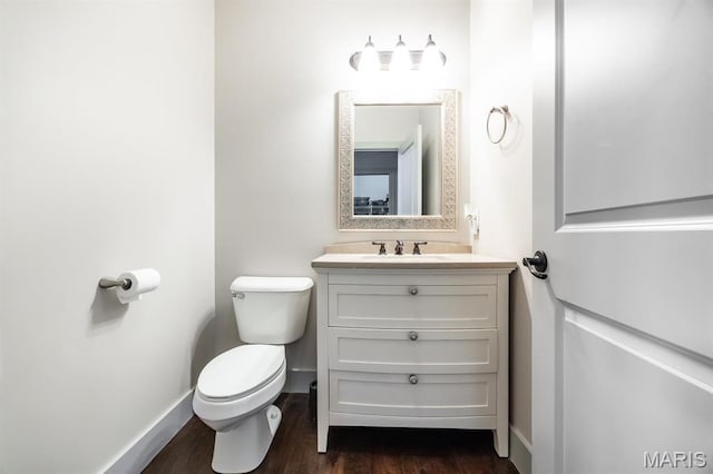 7032 Koufax Ct, Edwardsville, IL 62025 - half bathroom featuring toilet, wood finished floors, vanity, and baseboards