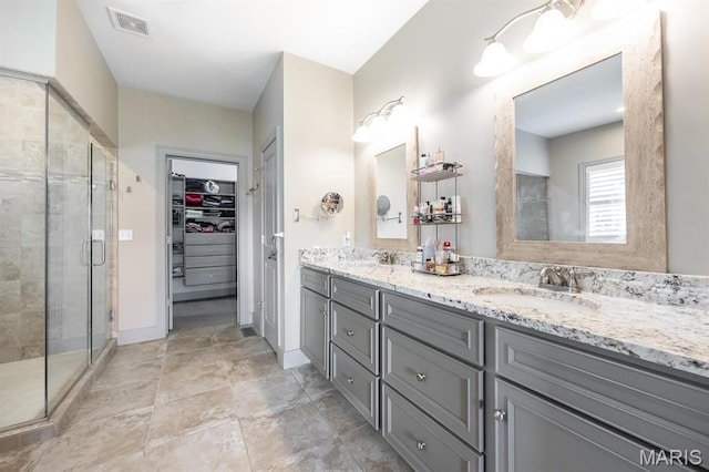 7032 Koufax Ct, Edwardsville, IL 62025 - bathroom featuring a stall shower, a walk in closet, double vanity, and baseboards