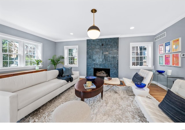 7825 Lafon Pl, Saint Louis, MO 63130 - living area featuring wood finished floors, ornamental molding, baseboards, a fireplace, and recessed lighting