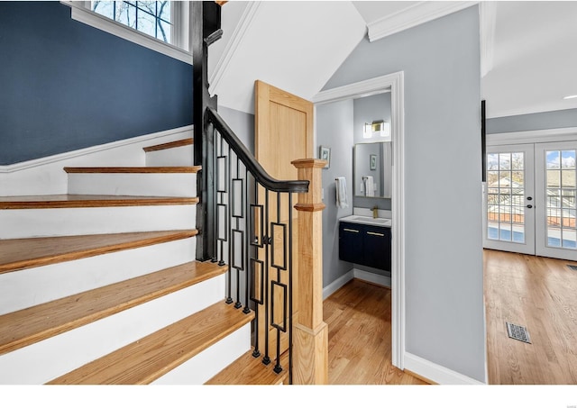 7825 Lafon Pl, Saint Louis, MO 63130 - staircase featuring wood finished floors, french doors, healthy amount of natural light, and baseboards