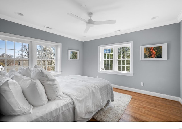 7825 Lafon Pl, Saint Louis, MO 63130 - bedroom featuring multiple windows, light wood finished floors, baseboards, crown molding, and a ceiling fan