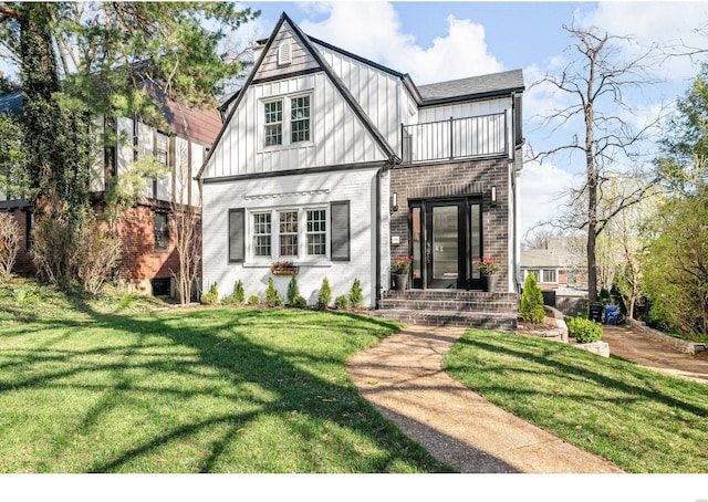 7825 Lafon Pl, Saint Louis, MO 63130 - english style home with a balcony, brick siding, board and batten siding, and a front lawn