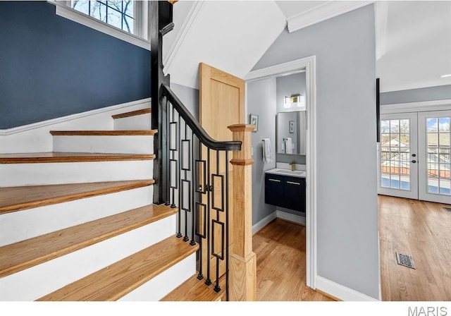 7825 Lafon Pl, Saint Louis, MO 63130 - staircase featuring french doors, wood finished floors, plenty of natural light, and baseboards