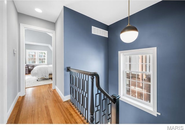 7825 Lafon Pl, Saint Louis, MO 63130 - hall featuring an upstairs landing, wood finished floors, and baseboards