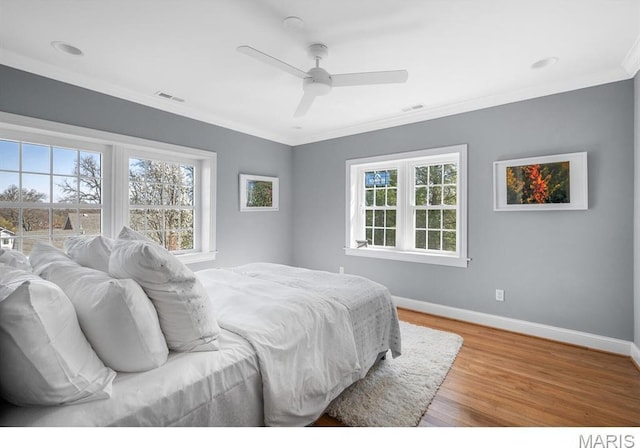 7825 Lafon Pl, Saint Louis, MO 63130 - bedroom with multiple windows, baseboards, light wood-style floors, crown molding, and ceiling fan