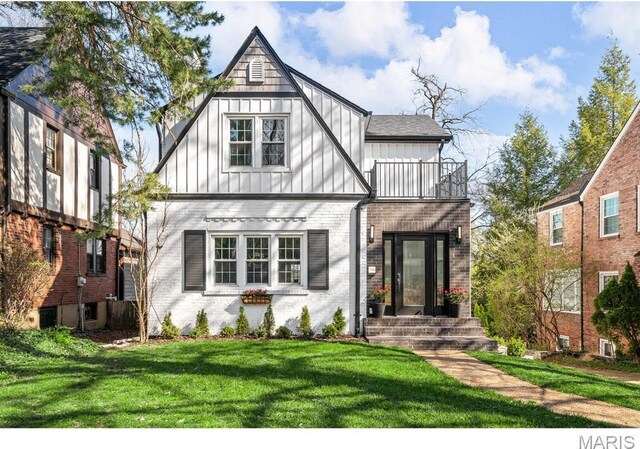 7825 Lafon Pl, Saint Louis, MO 63130 - tudor home with a balcony, board and batten siding, brick siding, and a front yard