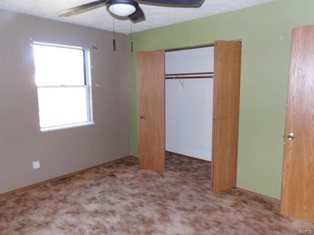 unfurnished bedroom featuring a closet, carpet flooring, and ceiling fan
