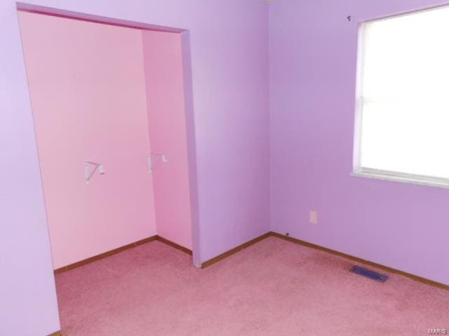 spare room with light colored carpet and baseboards