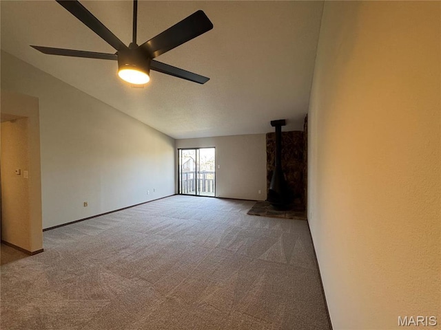 1400 Heritage Gdn # 305, Saint Charles, MO 63303 - unfurnished living room with carpet floors, a wood stove, ceiling fan, and baseboards