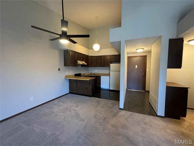 1400 Heritage Gdn # 305, Saint Charles, MO 63303 - kitchen featuring white appliances, under cabinet range hood, dark colored carpet, dark brown cabinetry, and baseboards
