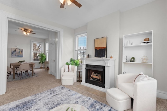 living room with a ceiling fan, plenty of natural light, and carpet