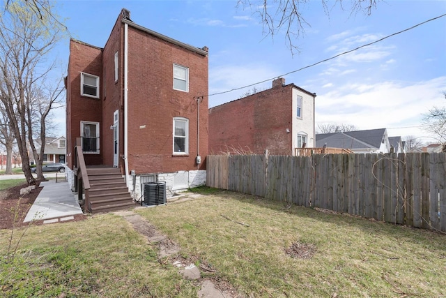 back of property featuring brick siding and central AC unit