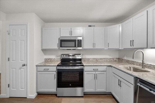 7600 Triwoods Dr Unit G, Saint Louis, MO 63119 - kitchen with appliances with stainless steel finishes, a sink, light wood-type flooring, and light stone countertops