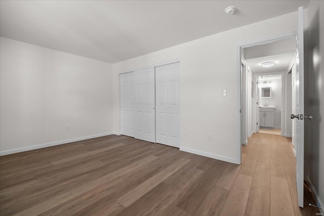 7600 Triwoods Dr Unit G, Saint Louis, MO 63119 - unfurnished bedroom featuring wood finished floors, baseboards, a closet, and a sink