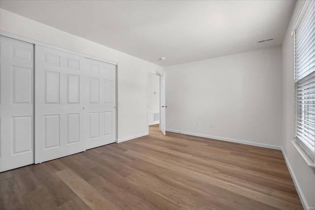 7600 Triwoods Dr Unit G, Saint Louis, MO 63119 - unfurnished bedroom with wood finished floors, baseboards, a closet, and multiple windows