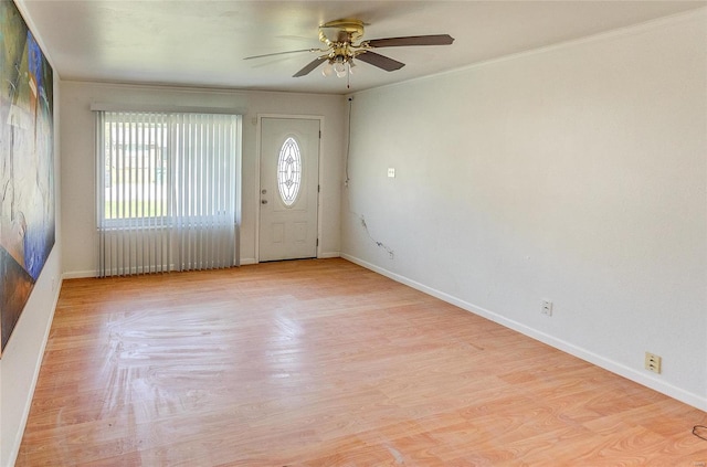 foyer entrance with a ceiling fan, baseboards, wood finished floors, and ornamental molding