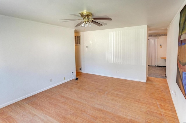 unfurnished room featuring a ceiling fan, crown molding, light wood finished floors, and baseboards