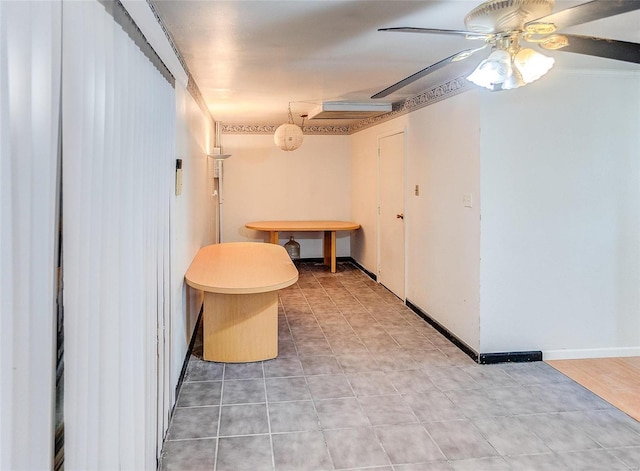 below grade area with a ceiling fan and light tile patterned floors