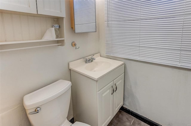 half bathroom with vanity, toilet, and tile patterned floors