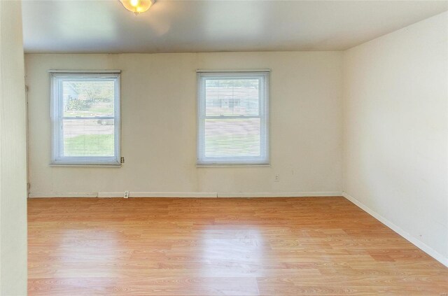 spare room with light wood finished floors and baseboards