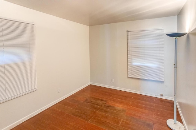 unfurnished room with wood finished floors and baseboards