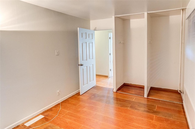 unfurnished bedroom with light wood-style floors, a closet, and baseboards