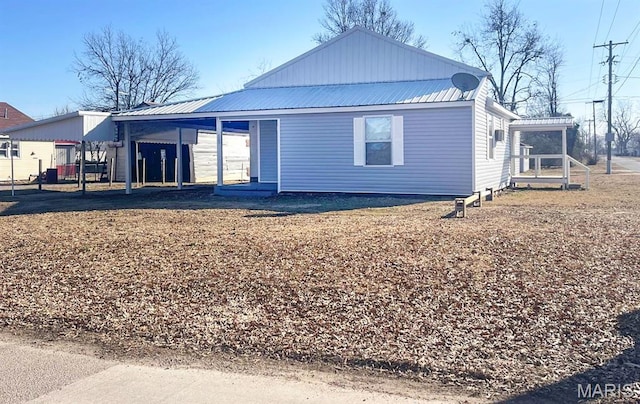 back of property with a carport and metal roof