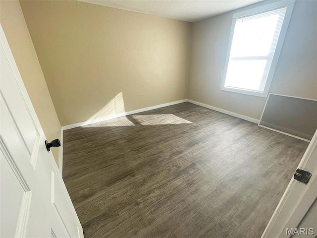 spare room with wood finished floors and baseboards