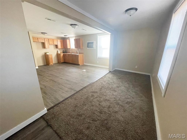 unfurnished living room featuring baseboards, wood finished floors, and carpet floors