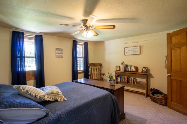bedroom with carpet flooring, a ceiling fan, and a textured ceiling