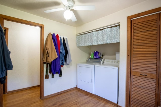 laundry area featuring washer and clothes dryer, light wood-type flooring, and baseboards