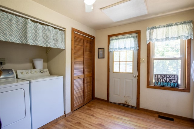 washroom with washing machine and dryer, baseboards, and light wood-style flooring