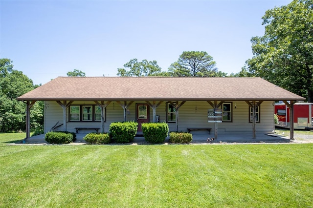 view of front of house with a front yard, covered porch, and a shingled roof