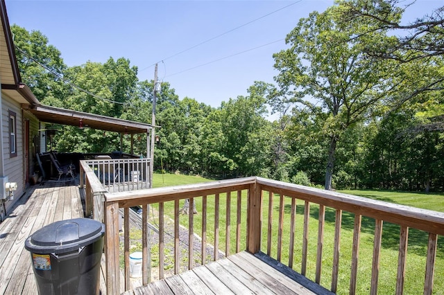 deck with a lawn and view of wooded area