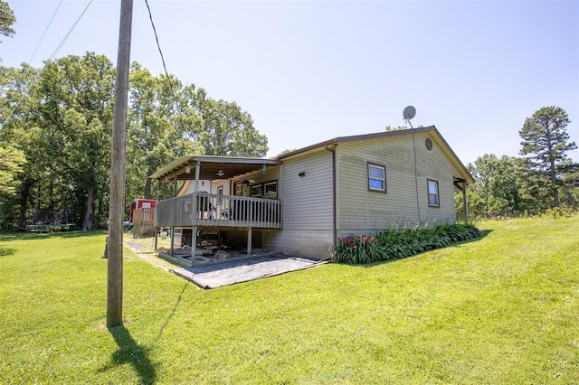 rear view of house featuring a deck, a lawn, and a patio