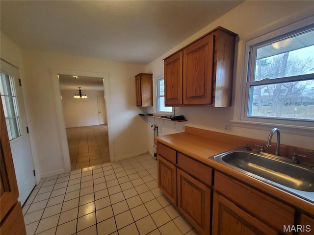 528 Dogwood Ln, Houston, MO 65483 - kitchen with a sink, brown cabinetry, light tile patterned floors, baseboards, and light countertops