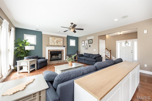 living area with ceiling fan, wood finished floors, baseboards, a fireplace, and recessed lighting