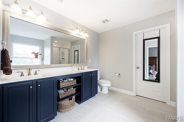 bathroom featuring double vanity, a stall shower, baseboards, and toilet