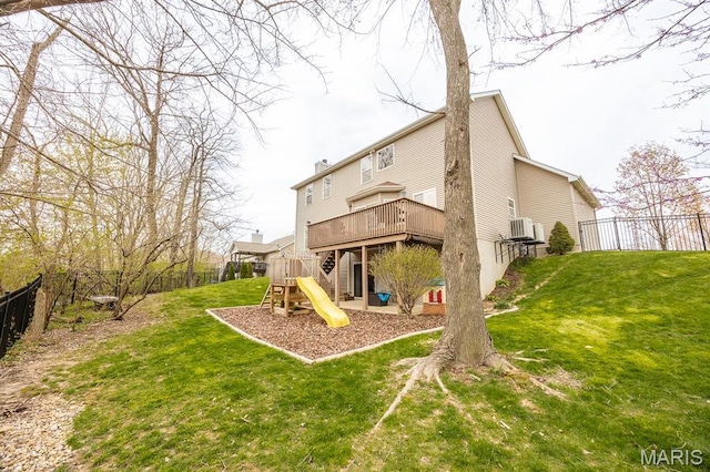 back of property with a playground and a wooden deck