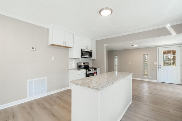 1107 Hickory St, Poplar Bluff, MO 63901 - kitchen with appliances with stainless steel finishes, crown molding, light wood finished floors, baseboards, and white cabinets