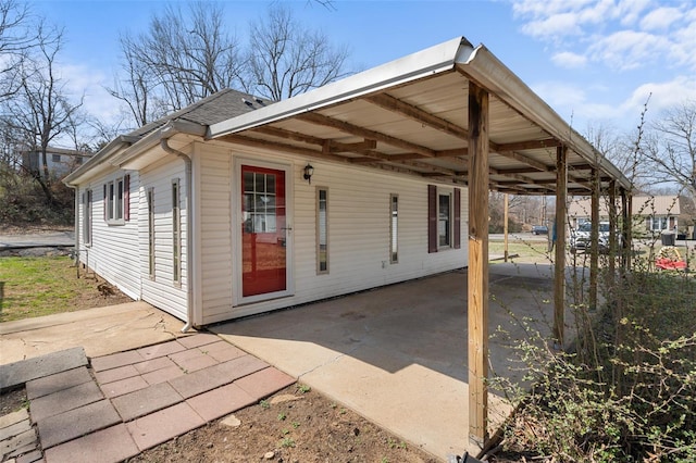 1107 Hickory St, Poplar Bluff, MO 63901 - back of house featuring a patio area, a carport, and a shingled roof