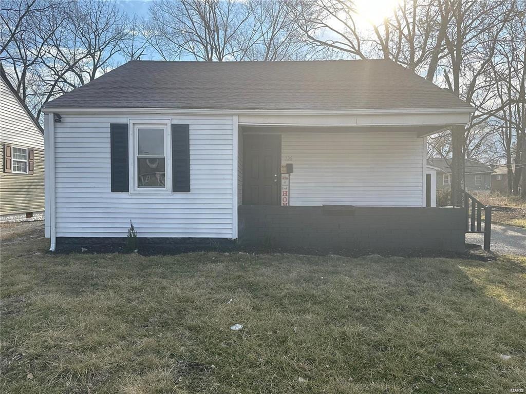 view of front of property with a front yard and a shingled roof