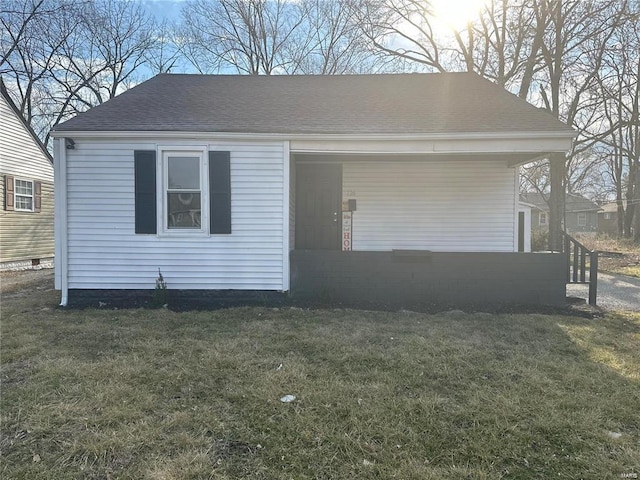 view of front of property with a front yard and a shingled roof