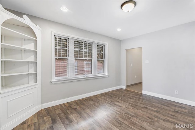 empty room with wood finished floors, baseboards, and recessed lighting