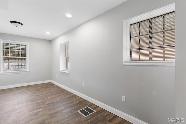 spare room with baseboards, wood finished floors, and recessed lighting