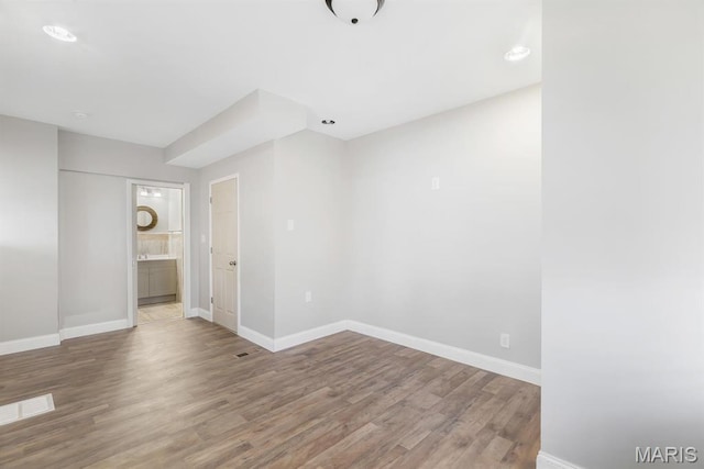 empty room with baseboards and wood finished floors