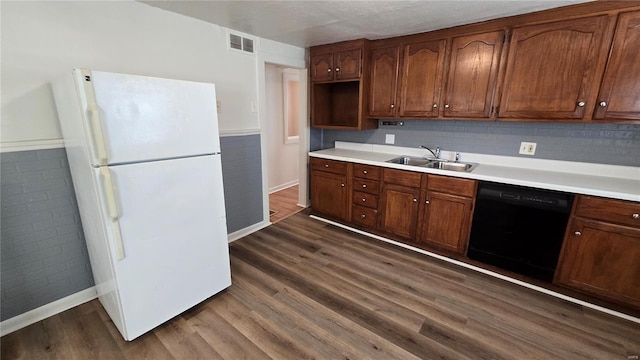 3240 Airway Ave, Saint Louis, MO 63114 - kitchen with freestanding refrigerator, black dishwasher, a sink, dark wood-type flooring, and light countertops