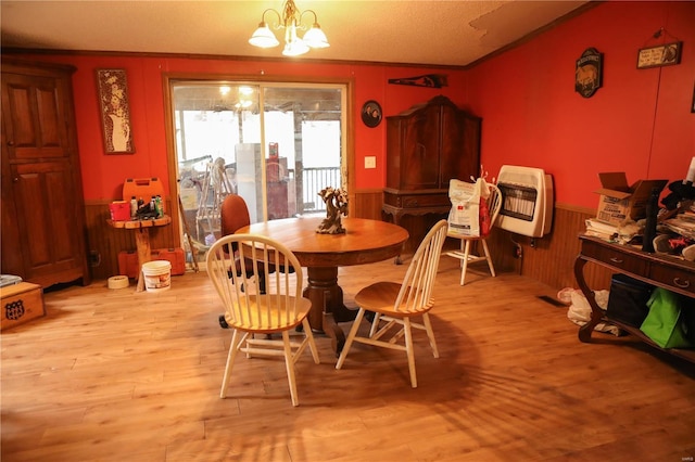 25125 Ash Dr, Grovespring, MO 65662 - dining area with a chandelier, wainscoting, heating unit, light wood-style floors, and wooden walls
