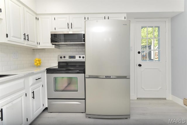 1680 Herault Pl Unit F, Saint Louis, MO 63125 - kitchen featuring appliances with stainless steel finishes, light wood finished floors, white cabinets, tasteful backsplash, and baseboards